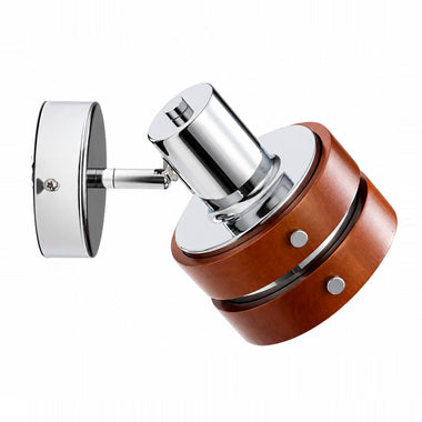 A modern wall-mounted light fixture with a polished chrome metal head and mounting bracket, paired with a cylindrical warm brown wood-grain shade, shown against a plain white background.